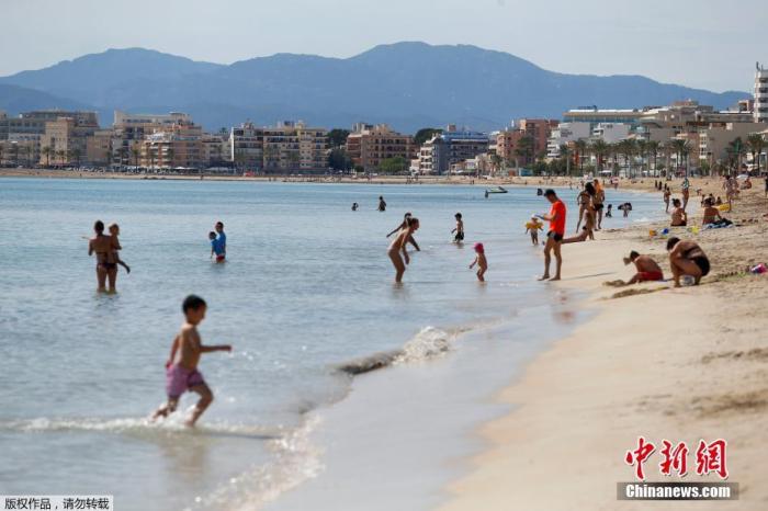 资料图：当地时间5月25日，民众在西班牙大加那利岛重新开放的海滩上玩乐休闲。据报道，随着疫情缓解，西班牙逐步放宽限制措施，一些省份放宽了解封第二阶段的一些限制。