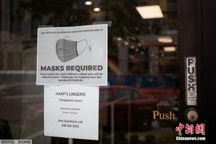 当地时间5月27日，美国一家商店的门上贴出进店需佩戴口罩的标识。