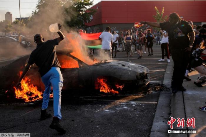 明尼阿波利斯市示威者点燃停车场的汽车。
