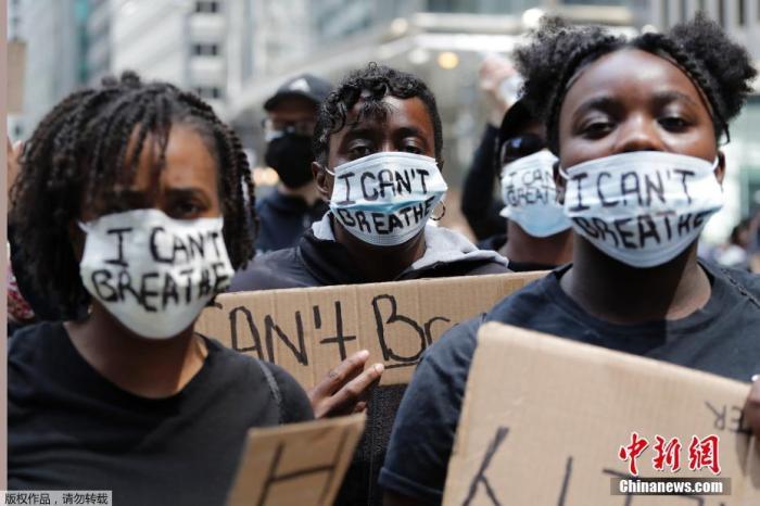 当地时间5月30日，美国芝加哥，几名抗议者戴着写有“我无法呼吸”字样的口罩走上街头抗议示威。
