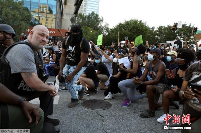 当地时间6月1日，美国乔治亚州亚特兰大市中心，警察和参加游行示威活动的民众一起跪地抗议针对美国非裔男子暴力执法的行为。