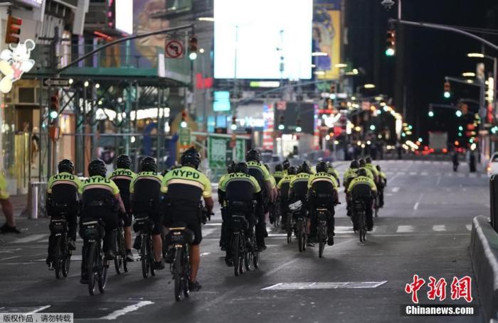 图为纽约警察在时代广场附近骑自行车巡逻。