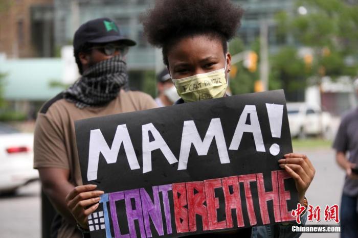 当地时间6月6日，在位于加拿大多伦多的安大略省省议会大楼前参加反种族主义游行集会的一位女子展示写有“妈妈，我无法呼吸”的标语。
<a target='_blank' href='http://www.chinanews.com/'>中新社</a>记者 余瑞冬 摄