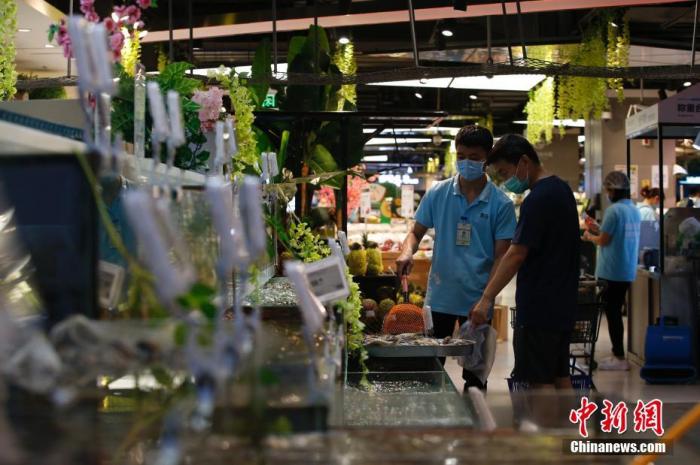 资料图：市民在超市挑选水产品。中新社记者 蒋启明 摄