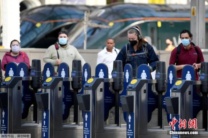 当地时间6月15日，英国伦敦，通勤者戴口罩乘坐公共交通。