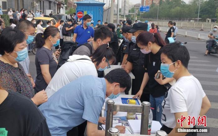 资料图：北京社区工作人员登记进出小区人员信息。中新社记者 杜洋 摄