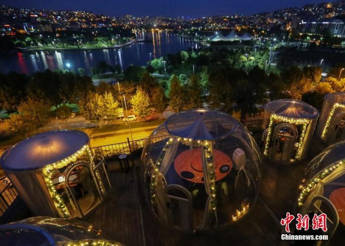 资料图：土耳其伊斯坦布尔，为保持用餐期间“社交距离”，一家餐厅设置了“圆顶”形状的隔离用餐区。图片来源：视觉中国