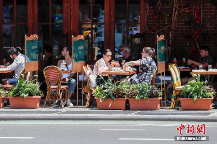 当地时间6月22日，纽约曼哈顿一家餐厅，顾客在户外用餐。当日，纽约市按预定计划进入第二阶段重启，市政府预计将有约30万人重返工作岗位。按照纽约州的重启规则，第二阶段重启中，零售店、理发店等商家满足条件可以开展室内经营。餐厅可以申请设置室外用餐区。商场、影剧院、健身房等依然保持关闭。
<a target='_blank' href='http://www.chinanews.com/'>中新社</a>记者 廖攀 摄