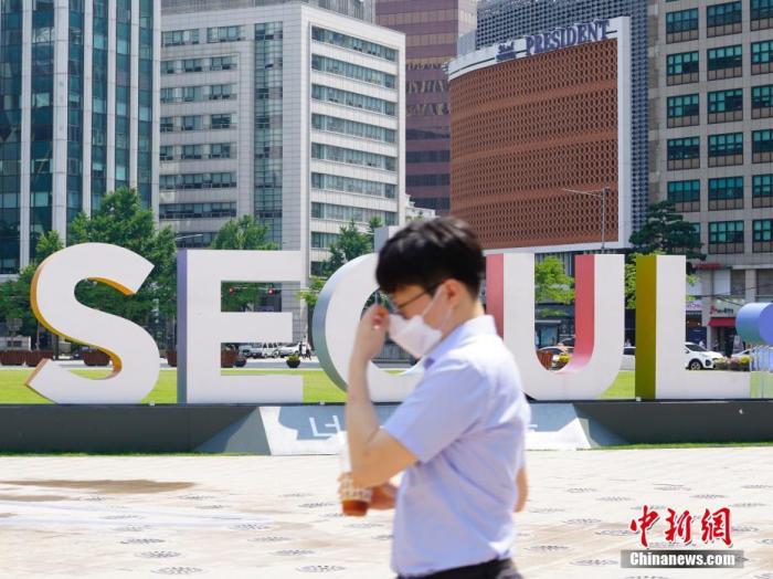 资料图：6月23日，一位韩国首尔市民经过首尔广场。<a target='_blank' href='http://www.chinanews.com/'>中新社</a>记者 曾鼐 摄