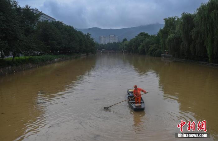 6月25日，工作人员在水位上涨的河道中清理垃圾。当日，浙江杭州遭遇强降雨，城市河道水位上涨。
<a target='_blank' href='http://www.chinanews.com/'>中新社</a>记者 王刚 摄