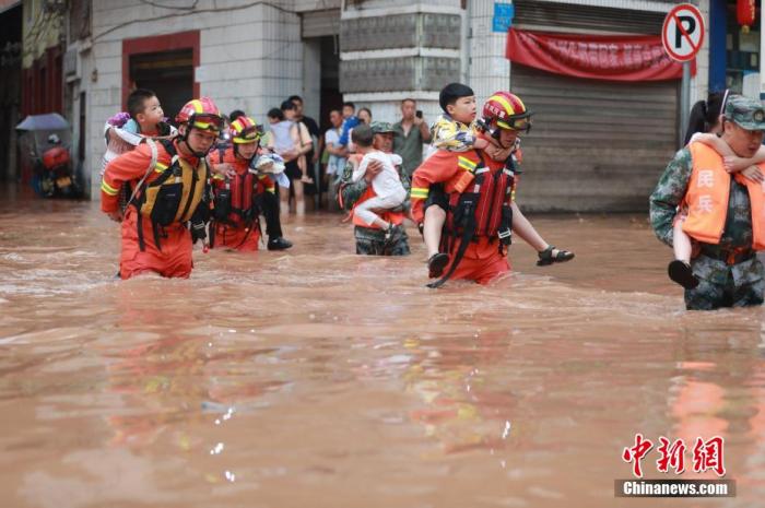 资料图：消防救援人员紧急转移被困民众。肖乐峰 摄