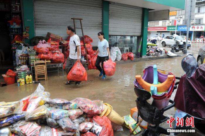 图为洪水退去后，歙县县城内的商户们在清理淤泥杂物。 张娅子 摄