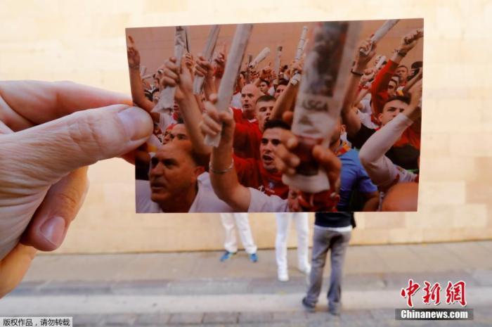 当地时间2020年7月7日，西班牙潘普洛纳，圣佛明节狂欢活动因疫情取消，摄影师手持一张跑步者参与传统歌唱的照片，再现圣佛明节狂欢活动盛况。