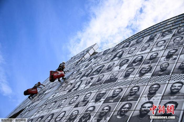 当地时间7月8日，法国巴黎，法国艺术家Jean Rene aka JR创作巨幅马赛克作品，由医护人员的肖像组成，以向医护人员致敬。该作品由专业登山运动员安装在巴士底歌剧院外。
