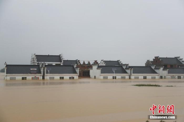 7月10日下午，江西省鄱阳县圩堤漫溃洪灾现场，乡村道路两侧的一些民房已浸泡在洪水之中。刘占昆 摄