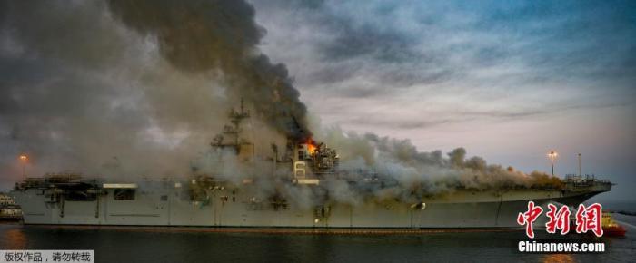 当地时间7月13日，美国海军两栖攻击舰“好人理查德”号大火进入第二天，军方说已有59人在火灾中受伤。图为“好人理查德”号舰体冒出滚滚浓烟。
