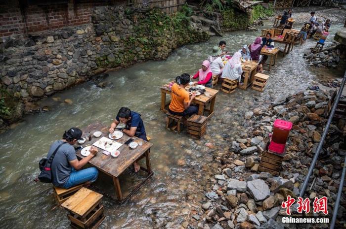 当地时间2020年7月14日，马来西亚吉隆坡，当地人在河边的餐馆外吃午饭。 图片来源：视觉中国