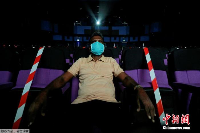 当地时间2020年7月11日，斯里兰卡科伦坡，一名戴着口罩的观众在电影院看电影。