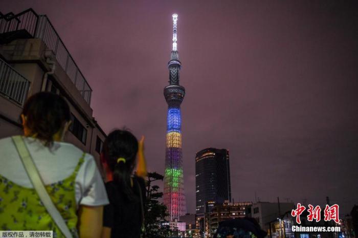 资料图：当地时间2020年7月23日，日本东京，东京奥运会倒计时一周年，东京晴空塔亮起奥运五环色灯光。