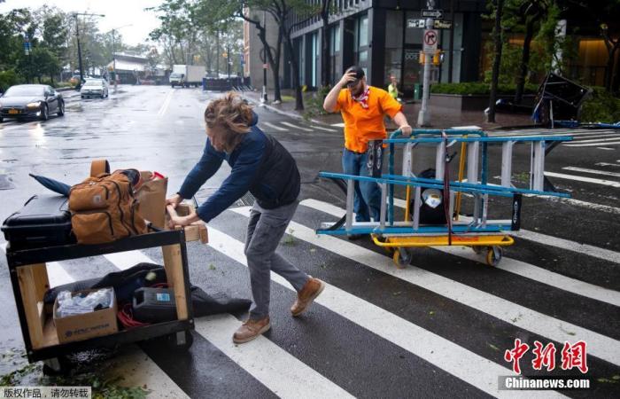 当地时间8月4日，热带风暴伊萨亚斯（Isaias）登陆美国，纽约市民在强风中艰难前行。