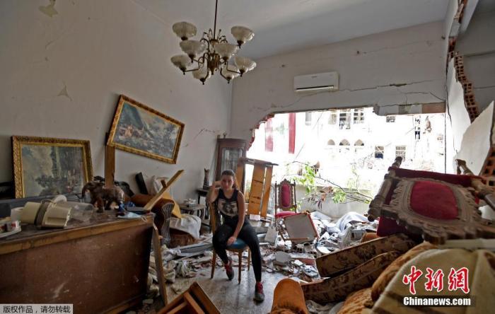 当地时间8月6日，黎巴嫩首都贝鲁特，一名妇女坐在被毁房屋的废墟中。当地时间4日，黎巴嫩首都发生大爆炸，以至于黎巴嫩首都就像经历了一场地震，数以千计的人无家可归，还有数以千计的人挤进拥挤不堪的医院接受治疗。
