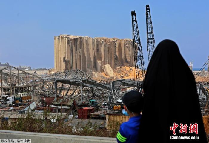 8月12日，黎巴嫩首都贝鲁特，一名妇女带着她的儿子注视着被大爆炸破坏的粮仓。