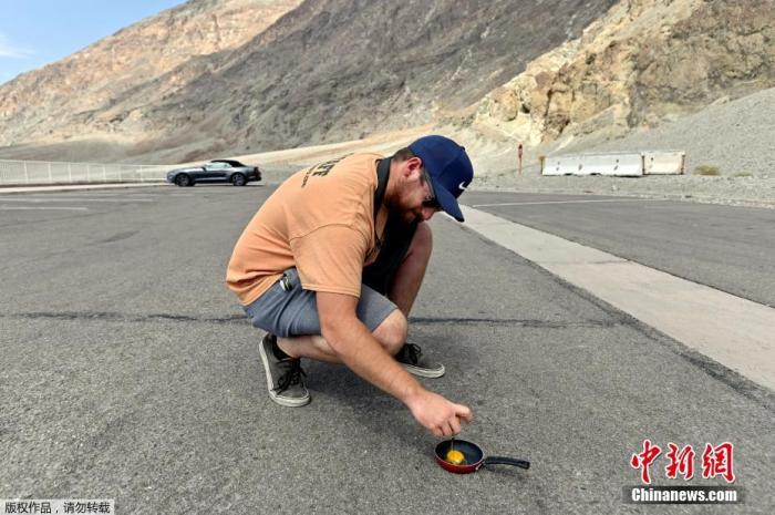 当地时间8月17日，美国加利福尼亚州死亡谷国家公园巴德沃特盆地的停车场，一名男子尝试在地面上煎蛋。
