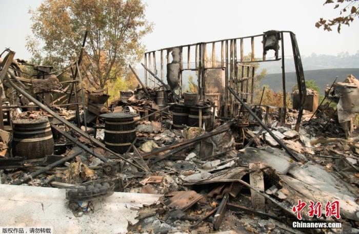 当地时间8月23日，美国加州纳帕市山火持续肆虐，当地一家酒庄被毁，酒庄的老板Gerry Iulano在酒庄的废墟中品尝经过山火洗礼过的葡萄酒。