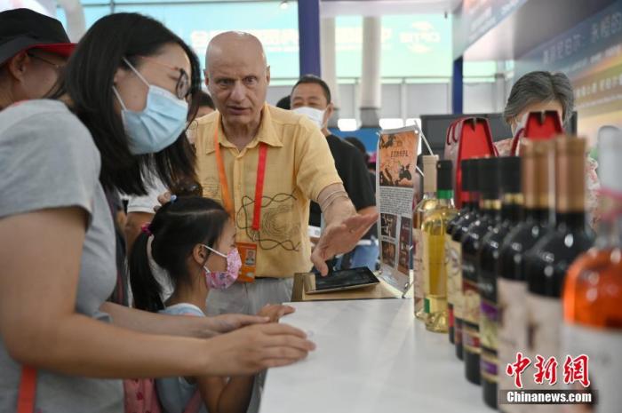资料图：9月6日，北京，在2020年中国国际服务贸易交易会国别和省区市专区，摩尔多瓦共和国展位的工作人员向参观者介绍葡萄酒。
中新社记者 张兴龙 摄