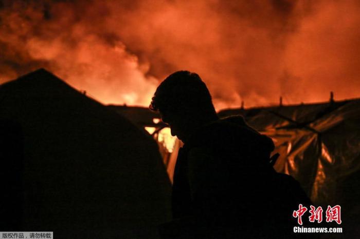 当地时间9月9日，希腊莱斯博斯岛的莫里亚难民营发生大火后，难民离开着火地。