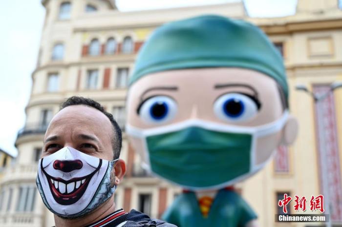 当地时间2020年9月24日，西班牙马德里，市中心放置了一樽6米高的“超级医护工作者”的雕像，该雕像旨在向与新冠病毒抗争的医护人员们致敬，路过的行人们与其拍照合影。 图片来源：人民视觉
