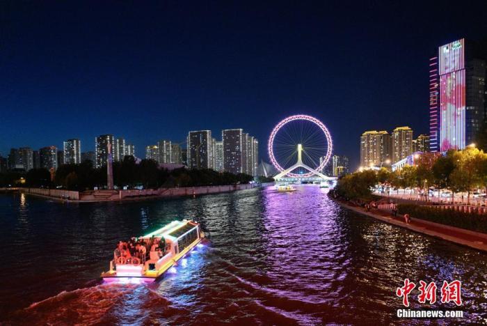 10月4日晚，市民和游客乘坐游船观赏海河夜景。国庆假期，天津海河沿岸夜景灯光全线开启，夜色流光溢彩，璀璨夺目。
中新社记者 佟郁 摄