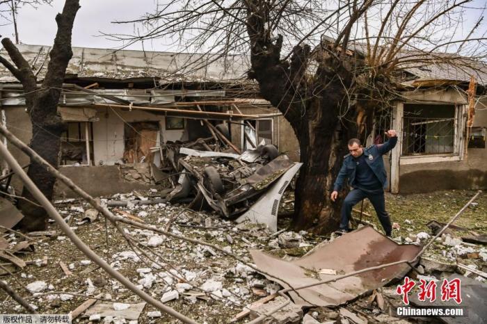 当地时间10月7日，在亚美尼亚和阿塞拜疆的武装冲突中，纳卡地区主要城市斯捷潘纳克特发生炮击之后，一名警察在废墟中行走。