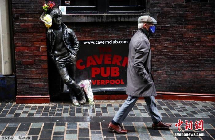当地时间10月12日，英国利物浦，一名男子带着口罩在路上行走。