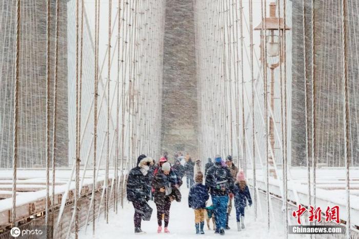 资料图：民众在纽约暴风雪中穿越布鲁克林大桥。图片来源：ICphoto