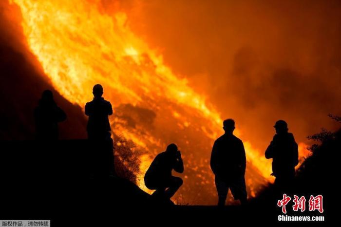 当地时间10月26日，美国加州野火迅速蔓延，导致数万居民被迫撤离。顺势蔓延的野火在夜晚如同岩浆流过山野。