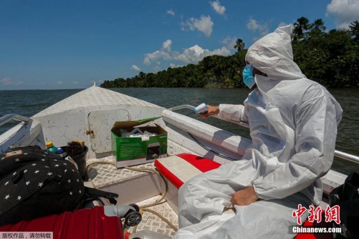 当地时间10月28日，巴西帕拉州东北部，医务工作者乘船为河边的原著居民测量体温，巴西卫生部准备迎接第二波新冠肺炎疫情，加强预防措施。