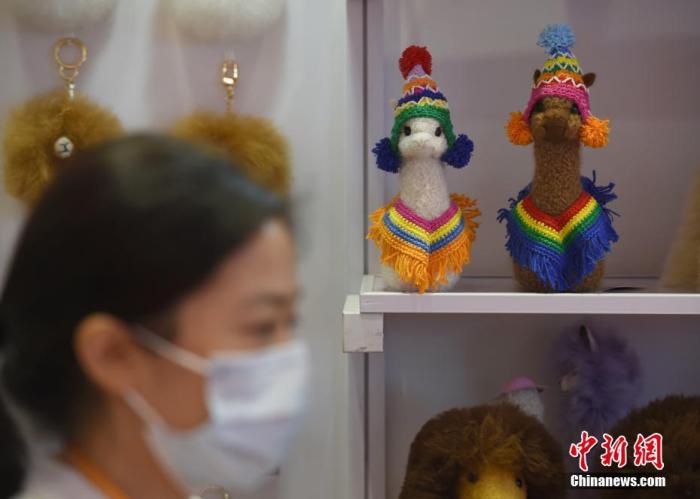 第三届中国国际进口博览会消费品展区内，参展商马玉霞的秘鲁羊驼毛制品展台内展示着羊驼毛玩偶等产品。中新社记者 侯宇 摄