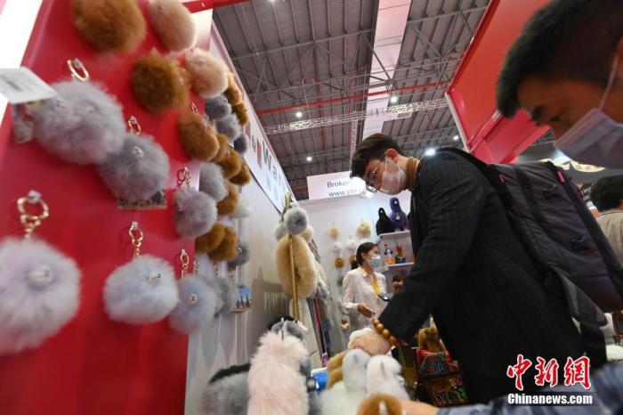 11月6日，上海，第三届中国国际进口博览会消费品展区内，参展商马玉霞的秘鲁羊驼毛制品展台吸引参会者的兴趣。
中新社记者 侯宇 摄