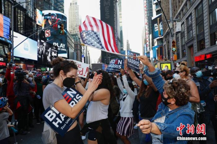 当地时间2020年11月7日，人们聚集在美国纽约时报广场。据美国媒体当日测算，民主党总统候选人、前副总统拜登在2020年美国总统选举中已获得超过270张选举人票。共和党总统候选人、现任总统特朗普随后表示，此次选举远未结束。当天，美国多地有拜登的支持者上街庆祝，也有特朗普的支持者上街抗议。 <a target='_blank' href='/'>中新社</a>记者 廖攀 摄