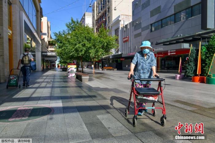 资料图：当地时间11月19日，南澳大利亚州首府阿德莱德，市民走在空旷的街道上。