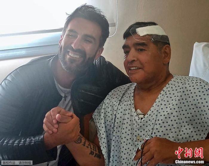 当地时间2020年11月11日，与他的私人医生合影。马拉多纳因贫血、脱水和抑郁而入院治疗。随后，核磁共振显示他有硬脑膜下血肿。随后，现年60岁的阿根廷足球巨星接受了脑部手术。
