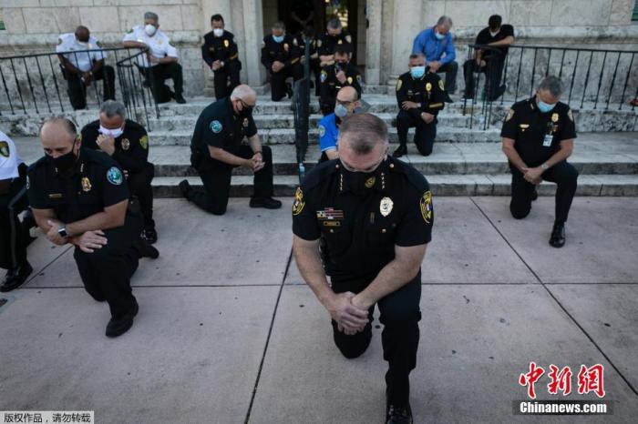 2020年5月，美国佛罗里达州，警察们单膝下跪声援“黑人的命也是命”运动。美国黑人乔治·弗洛伊德在手无寸铁的情况下被明尼阿波利斯警察逮捕并压在地上直至其死亡。Eva Marie UZCATEGUI 摄