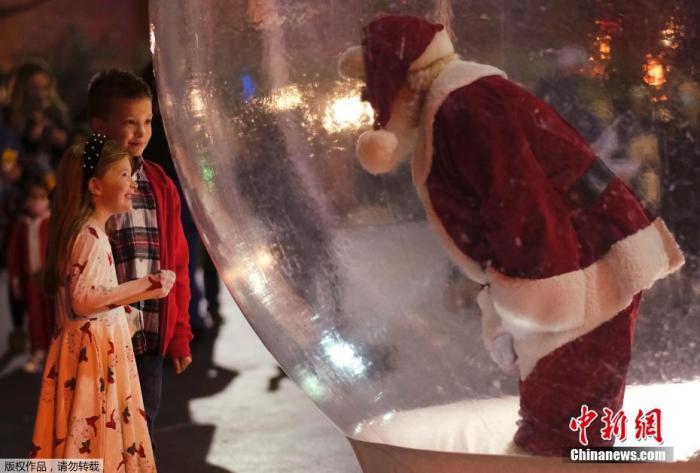 当地时间2020年12月5日，美国俄克拉何马州，为防止疫情期间产生过多接触，圣诞老人在气球中与游客互动。