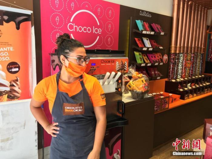 当地时间12月16日，巴西圣保罗，一名女店员戴着口罩在当地一家巧克力店推销圣诞礼品。<a target='_blank' href='http://www.chinanews.com/'>中新社</a>记者 莫成雄 摄