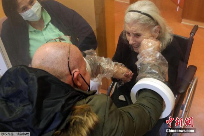 当地时间12月18日，意大利博洛尼亚一家养老院为防范新冠病毒设置“拥抱屋”，居住在这里的老人可以隔着玻璃与到访的家人团聚拥抱。