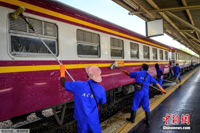 资料图：当地时间2021年1月4日，泰国曼谷，Hua Lamphong车站的工作人员对列车进行清洁消毒。