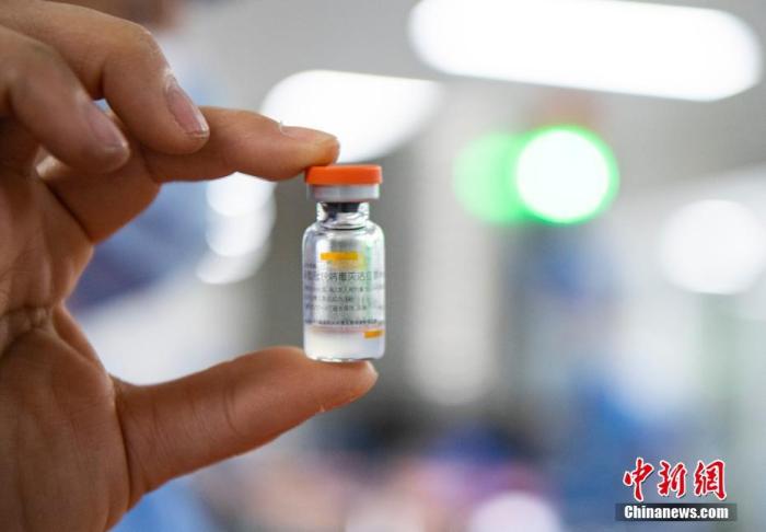 资料图：1月6日，中国新闻社记者前往位于北京市大兴区的北京科兴中维生物技术有限公司，探访新型冠状病毒灭活疫苗生产线。图为工作人员展示西林瓶装疫苗。
中新社记者 侯宇 摄