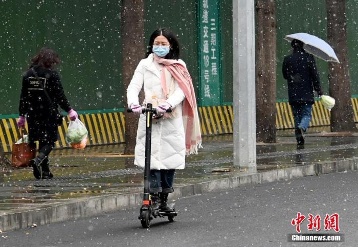 1月7日，四川省成都市主城区迎来2021年首场降雪，气温下降。图为市民在雪中出行。
中新社记者 安源 摄
