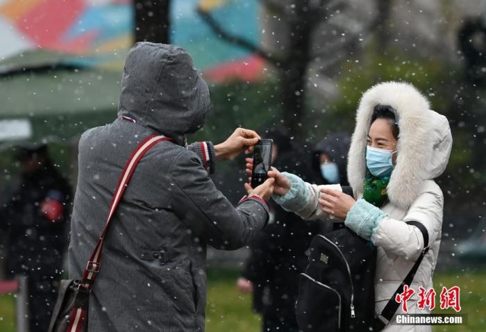 1月7日，四川省成都市主城区迎来2021年首场降雪，气温下降。图为市民在雪中拍照。
中新社记者 安源 摄